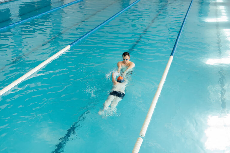 coach teaches sevenyearold boy swim modern swimming pool learn swim development children s sports healthy parenting promotion children s sports
