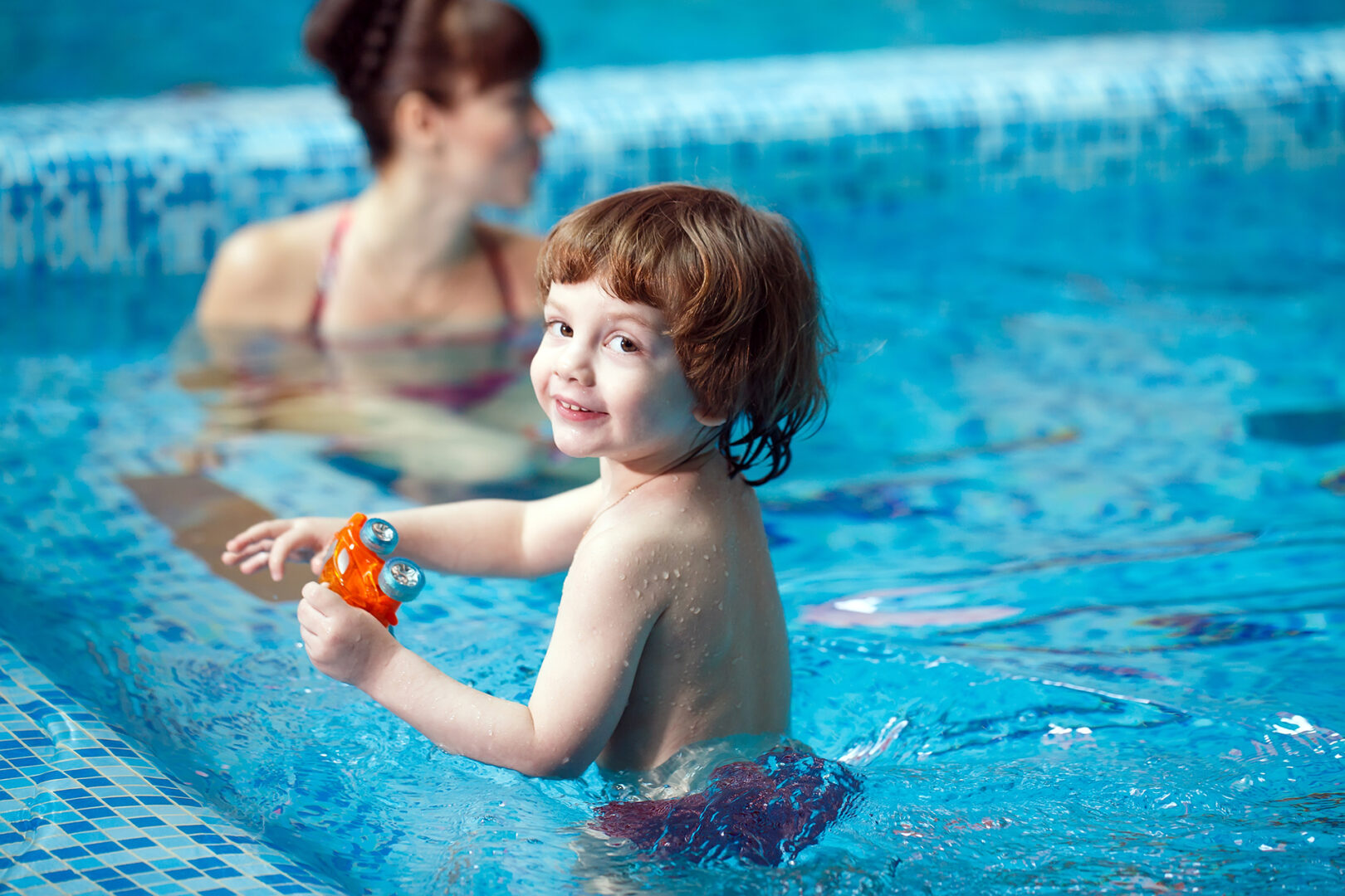 mom teaches child swim pool