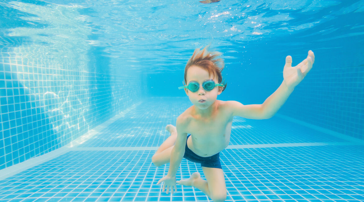 underwater young boy fun swimming pool with goggles summer vacation fun